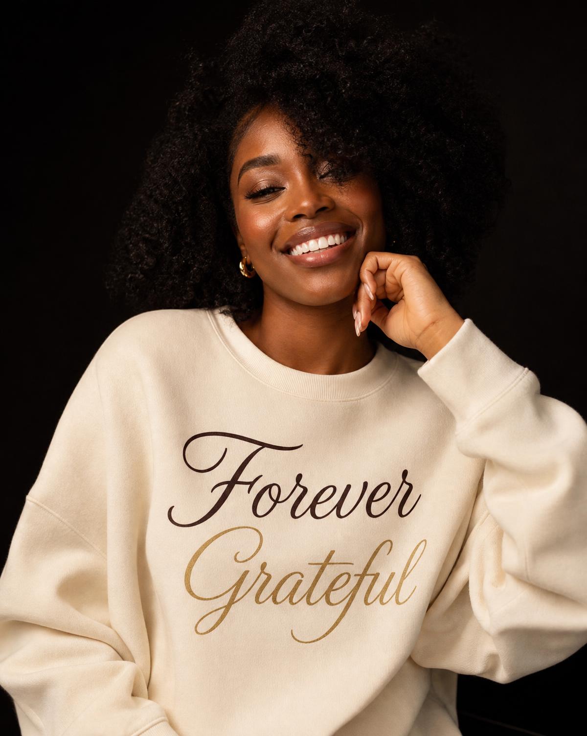 Black woman wearing a cream sweatshirt with the words Forever Grateful